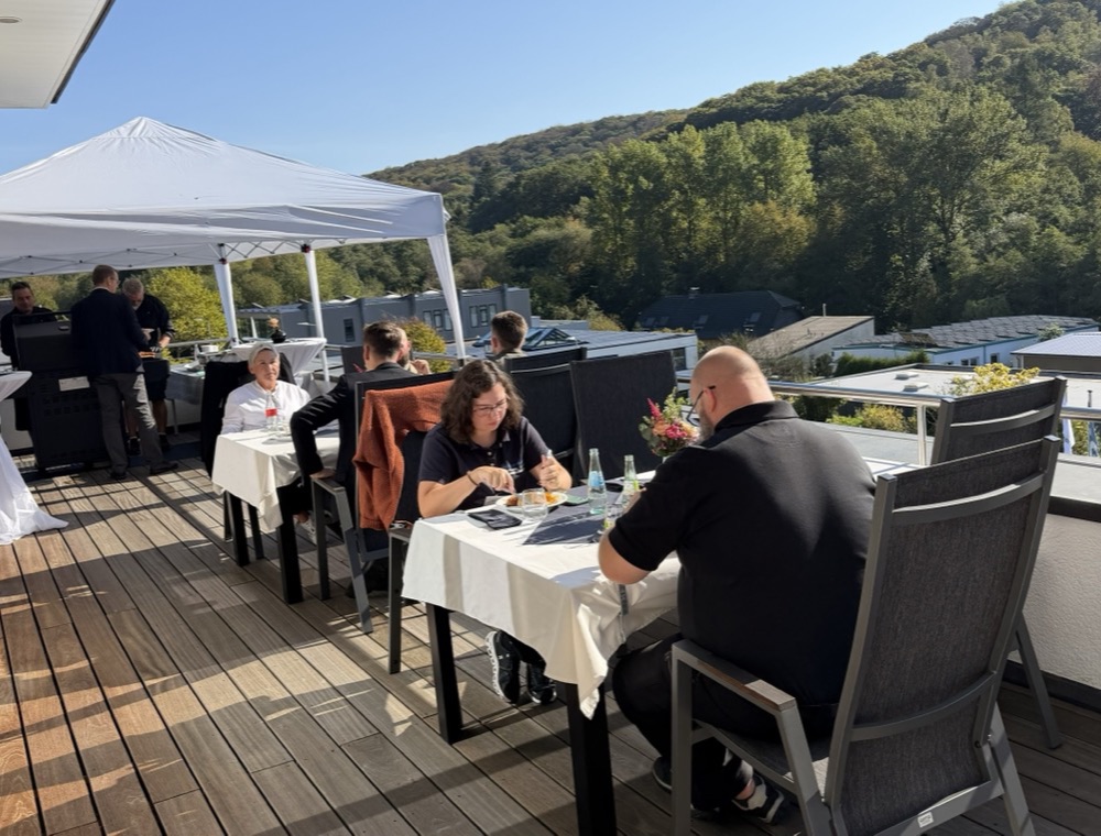 Gäste der m+m Hausmesse beim Essen auf der Dachterrasse mit Blick ins Grüne in Herdecke.